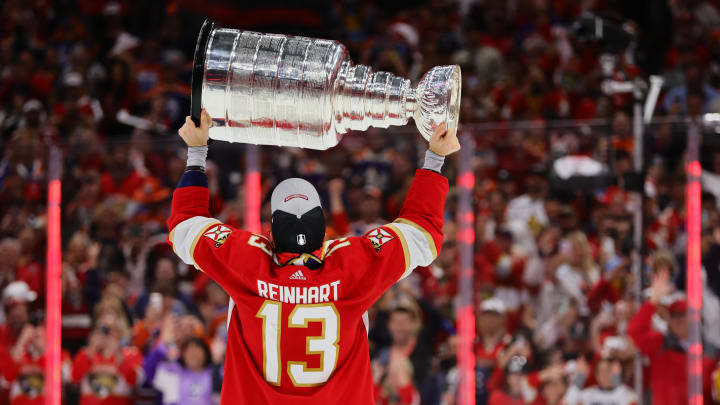 Jun 24, 2024; Sunrise, Florida, USA; Florida Panthers center Sam Reinhart (13) lifts the cup after winning game seven of the 2024 Stanley Cup Final against the Edmonton Oilers at Amerant Bank Arena. Mandatory Credit: Sam Navarro-USA TODAY Sports