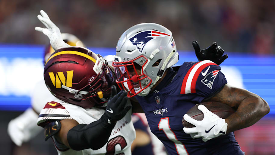 Washington Commanders cornerback Noah Igbinoghene tackles New England Patriots receiver Ja'Lynn Polk. | Paul Rutherford-Imagn Images