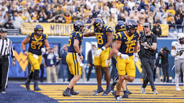 Nov 8, 2025; Morgantown, West Virginia, USA; West Virginia Mountaineers wide receiver Logan Ramper (18) celebrates with West Virginia Mountaineers quarterback Scotty Fox Jr. (15) after scoring a touchdown during the fourth quarter against the Colorado Buffaloes at Milan Puskar Stadium. Mandatory Credit: Ben Queen-Imagn Images