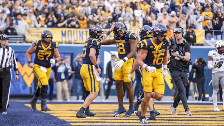 Nov 8, 2025; Morgantown, West Virginia, USA; West Virginia Mountaineers wide receiver Logan Ramper (18) celebrates with West Virginia Mountaineers quarterback Scotty Fox Jr. (15) after scoring a touchdown during the fourth quarter against the Colorado Buffaloes at Milan Puskar Stadium. Mandatory Credit: Ben Queen-Imagn Images