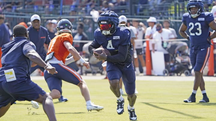 Running back D'Andre Swift sports a protective Guardian Cap as he runs around left end for the Bears in practice.