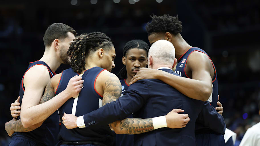 UConn coach Dan Hurley huddles with players on the court before their Elite Eight game.