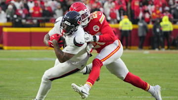 Jan 18, 2025; Kansas City, Missouri, USA; Houston Texans running back Dare Ogunbowale (33) runs the ball as Kansas City Chiefs safety Justin Reid (20) makes the tackle during the second half of a 2025 AFC divisional round game at GEHA Field at Arrowhead Stadium. Mandatory Credit: Denny Medley-Imagn Images