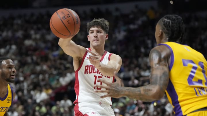 Jul 12, 2024; Las Vegas, NV, USA;  Houston Rockets guard Reed Sheppard (15) passes the ball between Los Angeles Lakers guard Bronny James (9) and forward Maxwell Lewis (21) during the first half at the Thomas & Mack Center. Mandatory Credit: Lucas Peltier-USA TODAY Sports