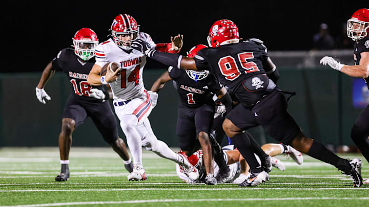 Toombs Quarterback TJ Stanley (14) attempts to break away from Savannah Christian's Elijah Griffin (No. 95) while his Raider teammate LaDamion Guyton (N0. 18) pursues Stanley from behind in a game at Pooler Stadium on Nov. 1, 2024. Toombs Quarterback TJ Stanley (14) attempts to break away from Savannah Christian's Elijah Griffin (No. 95) while his Raider teammate LaDamion Guyton (N0. 18) pursues Stanley from behind in a game at Pooler Stadium on Nov. 1, 2024.