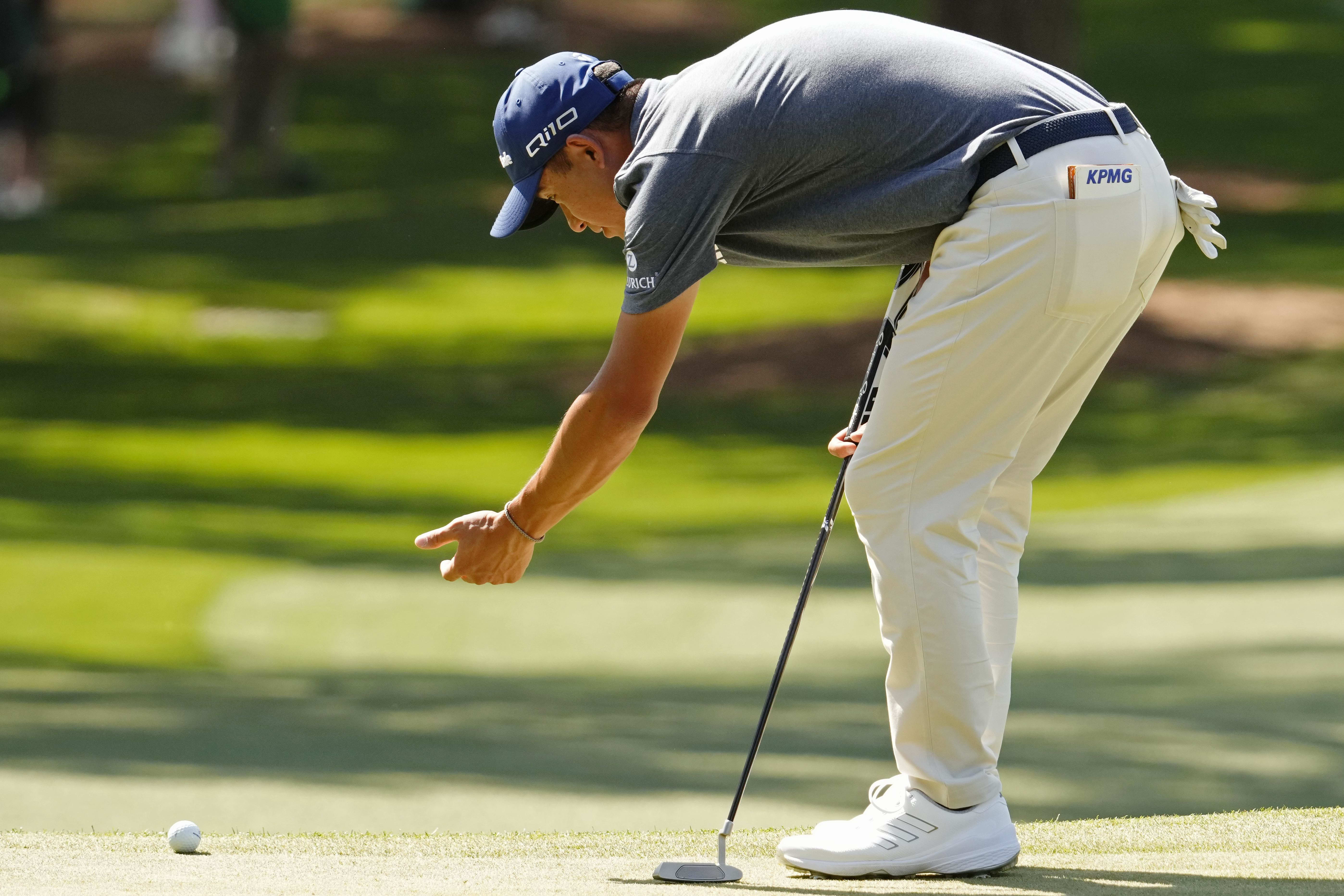 Collin Morikawa tries to determine if his ball is on the 7th green in the final round of the 2024 Masters.