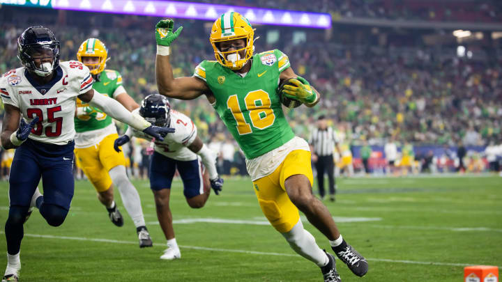 Jan 1, 2024; Glendale, AZ, USA; Oregon Ducks tight end Kenyon Sadiq (18) runs in a touchdown against the Liberty Flames during the second quarter of the 2024 Fiesta Bowl at State Farm Stadium. 