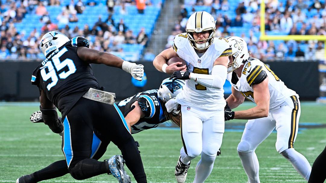 Nov 9, 2025; Charlotte, North Carolina, USA; New Orleans Saints quarterback Taysom Hill (7) rushes during the fourth quarter as Carolina Panthers defensive end Derrick Brown (95) defends at Bank of America Stadium. Mandatory Credit: Bob Donnan-Imagn Images