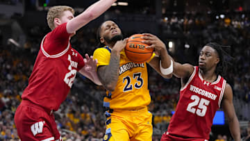 Dec 7, 2024; Milwaukee, Wisconsin, USA;  Marquette Golden Eagles forward David Joplin (23) drives for the basket between Wisconsin Badgers forward Steven Crowl (22) and guard John Blackwell (25) during the second half at Fiserv Forum. Mandatory Credit: Jeff Hanisch-Imagn Images