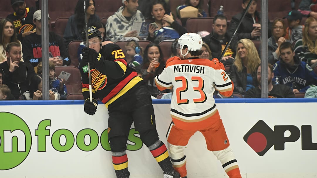 Apr 5, 2025; Vancouver, British Columbia, CAN;  Anaheim Ducks forward Mason McTavish (23) checks Vancouver Canucks defenseman Elias Pettersson (25) during the first period at Rogers Arena. Mandatory Credit: Anne-Marie Sorvin-Imagn Images