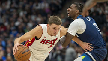 Nov 10, 2024; Minneapolis, Minnesota, USA; Miami Heat forward Nikola Jovic (5) drives to the basket past Minnesota Timberwolves center Naz Reid (11) in the second half at Target Center. 