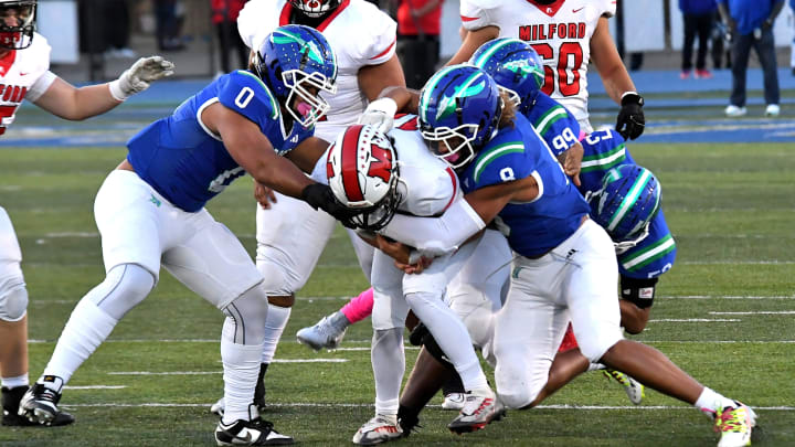 Cameron Jackson (0) and Justin Hill (8) drop Nathan Webster for a only a short gain for the Eagles at Winton Woods Stadium, Oct. 6, 2023.