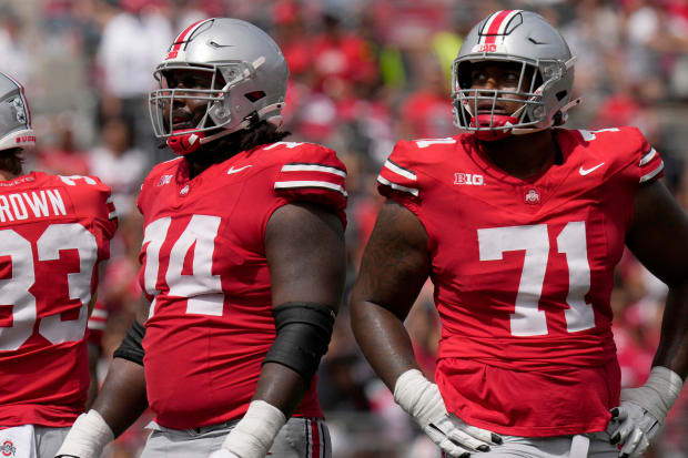 Offensive linemen look up at scoreboard.