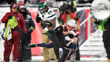 Jan 7, 2024; Foxborough, Massachusetts, USA; New York Jets running back Breece Hall (20) breaks a tackle by New England Patriots cornerback Myles Bryant (27) during the second half at Gillette Stadium.