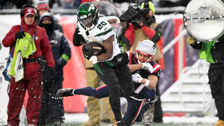 Jan 7, 2024; Foxborough, Massachusetts, USA; New York Jets running back Breece Hall (20) breaks a tackle by New England Patriots cornerback Myles Bryant (27) during the second half at Gillette Stadium.