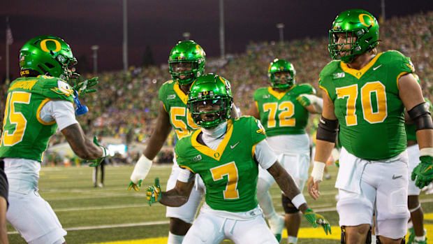 Oregon's Evan Stewart, center, celebrates a second quarter touchdown at Autzen Stadium in Eugene Sept. 7, 2024.