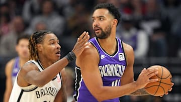 Nov 24, 2024; Sacramento, California, USA; Sacramento Kings forward Trey Lyles (right) handles the ball against Brooklyn Nets forward Noah Clowney (21) during the first quarter at Golden 1 Center. Mandatory Credit: Darren Yamashita-Imagn Images