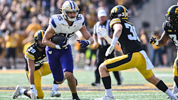 iOct 12, 2024; Iowa City, Iowa, USA; Washington Huskies tight end Keleki Latu (85) gets yards after the catch as Iowa Hawkeyes defensive back Quinn Schulte (30) looks to make the tackle during the first quarter at Kinnick Stadium. Mandatory Credit: Jeffrey Becker-Imagn Images