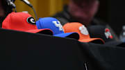Hats for Georgia, Kentucky, Clemson, and Ohio State sit on the table during his signing at Evans High School on Friday, April, 5, 2024. Short committed to play football at the University of Georgia.