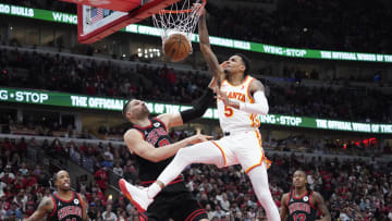 Apr 17, 2024; Chicago, Illinois, USA; Atlanta Hawks guard Dejounte Murray (5) dunks the ball on Chicago Bulls center Nikola Vucevic (9) during the second half during a play-in game of the 2024 NBA playoffs at United Center.