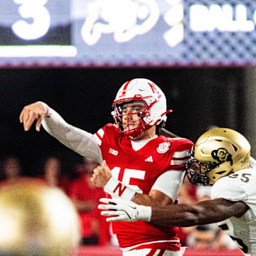 Sep 7, 2024; Lincoln, Nebraska, USA; Nebraska Cornhuskers quarterback Dylan Raiola (15) throws as he’s hit by Colorado Buffaloes defensive end BJ Green II (35) during the third quarter at Memorial Stadium. Mandatory Credit: Dylan Widger-Imagn Images