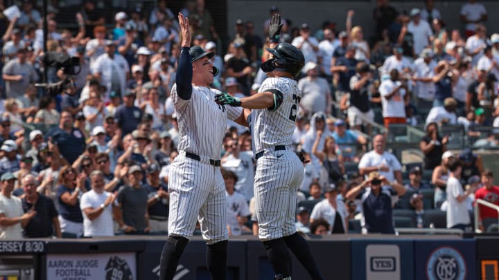 Aug 11, 2024; Bronx, New York, USA; New York Yankees designated hitter Giancarlo Stanton (27) celebrates after hitting a three run home run with center fielder Aaron Judge (99) during the fifth inning against the Texas Rangers at Yankee Stadium. Mandatory Credit: Vincent Carchietta-USA TODAY Sports