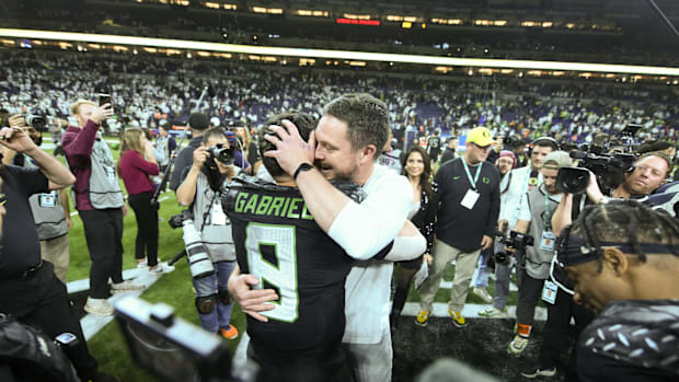 Dec 7, 2024; Indianapolis, IN, USA; Oregon Ducks head coach Dan Lanning hugs quarterback Dillon Gabriel (8) after defeating t