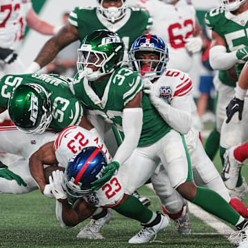 Aug 24, 2024; East Rutherford, New Jersey, USA; New York Giants cornerback Tre Herndon (23) is tackled by New York Jets linebacker Zaire Barnes (53) during the first quarter at MetLife Stadium. 