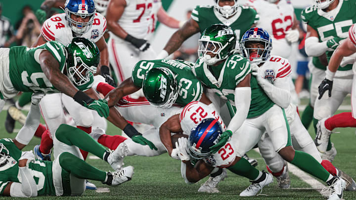 Aug 24, 2024; East Rutherford, New Jersey, USA; New York Giants cornerback Tre Herndon (23) is tackled by New York Jets linebacker Zaire Barnes (53) during the first quarter at MetLife Stadium. 