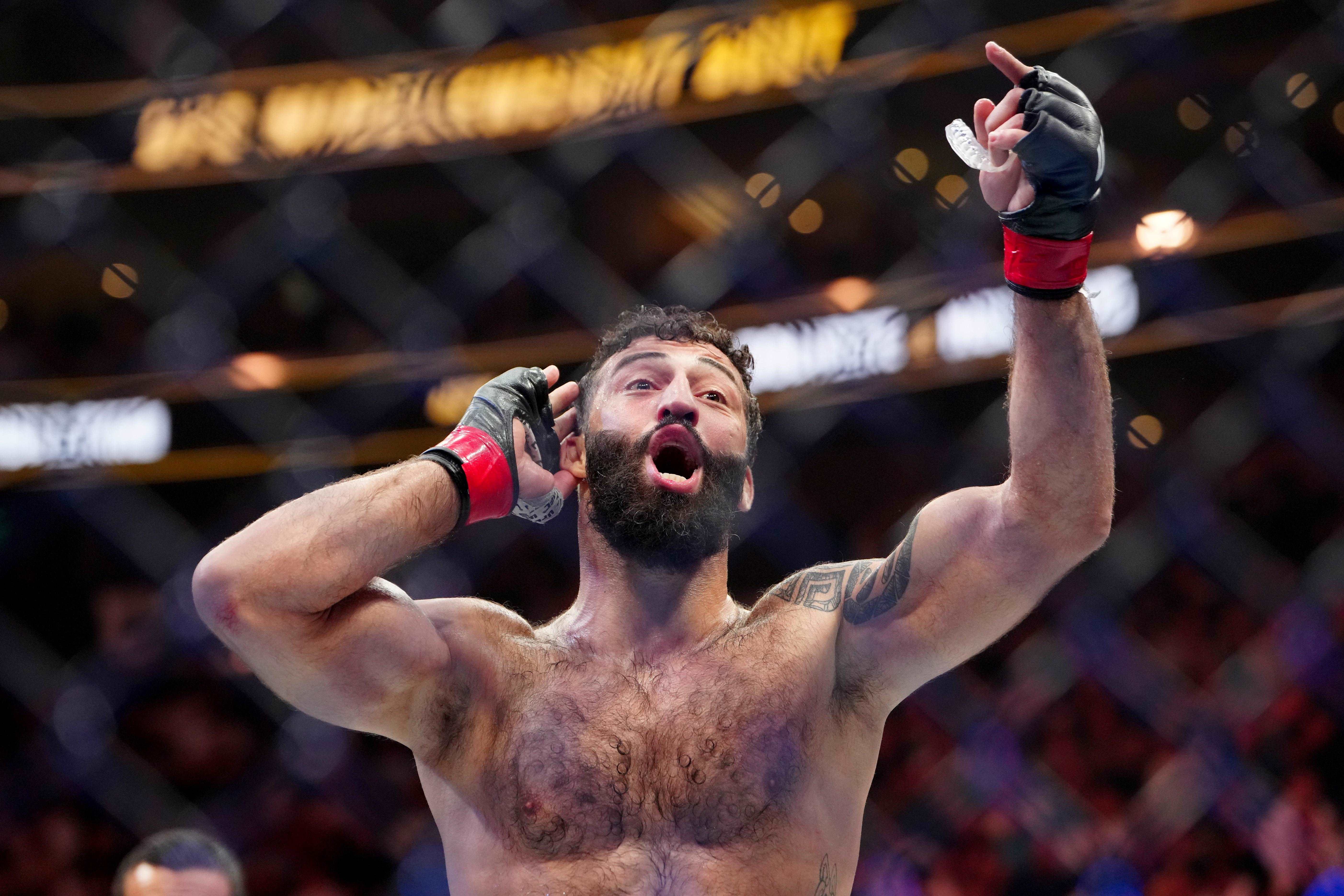 Roman Dolidze (red gloves) reacts after defeating Kevin Holland (not pictured) during UFC 307 at Delta Center.
