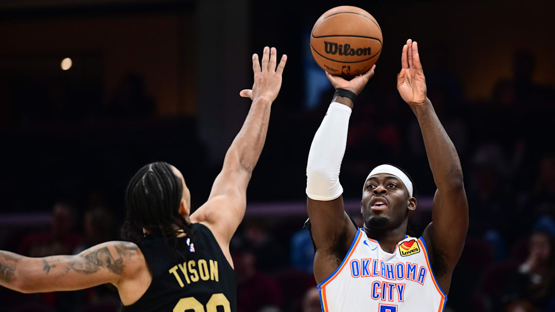 Jan 19, 2026; Cleveland, Ohio, USA; Oklahoma City Thunder guard Luguentz Dort (5) shoots over the defense of Cleveland Cavaliers guard Jaylon Tyson (20) during the first half at Rocket Arena. Mandatory Credit: Ken Blaze-Imagn Images