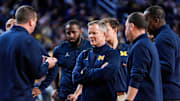 Michigan head coach Dusty May, center, talks to assistant coaches in a huddle at timeout against Villanova during the second half at Crisler Center in Ann Arbor on Tuesday, Dec. 9, 2025.