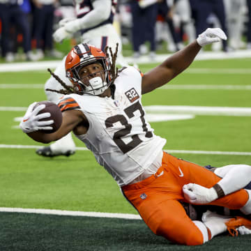 Jan 13, 2024; Houston, Texas, USA; Cleveland Browns running back Kareem Hunt (27) scores a touch down as he is tackled by Houston Texans defense in a 2024 AFC wild card game at NRG Stadium. Mandatory Credit: Thomas Shea-USA TODAY Sports
