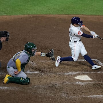 Sep 10, 2024; Houston, Texas, USA; Houston Astros second baseman Jose Altuve (27) hits a single against the Oakland Athletics in the ninth inning at Minute Maid Park.