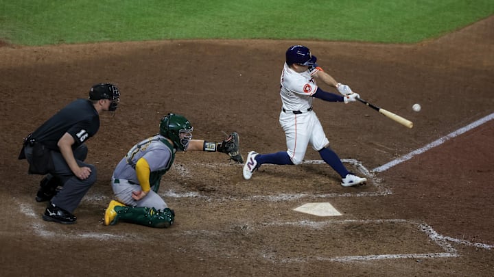 Sep 10, 2024; Houston, Texas, USA; Houston Astros second baseman Jose Altuve (27) hits a single against the Oakland Athletics in the ninth inning at Minute Maid Park.