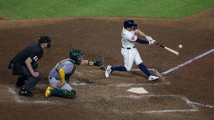 Sep 10, 2024; Houston, Texas, USA; Houston Astros second baseman Jose Altuve (27) hits a single against the Oakland Athletics in the ninth inning at Minute Maid Park. 