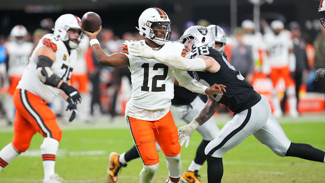 Nov 23, 2025; Paradise, Nevada, USA; Cleveland Browns quarterback Shedeur Sanders (12) looks to make a pass attempt as Las Vegas Raiders defensive end Maxx Crosby (98) tackles him during the third quarter at Allegiant Stadium. Mandatory Credit: Stephen R. Sylvanie-Imagn Images
