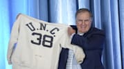 Dec 12, 2024; Chapel Hill, NC, USA;   North Carolina Tar Heels new head coach Bill Belichick holds up the sweatshirt worn by his father when he was an assistant coach at New North Carolina Tar Heels new at Loudermilk Center for Excellence. Mandatory Credit: Jim Dedmon-Imagn Images