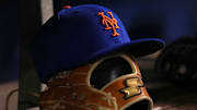 Aug 2, 2021; Miami, Florida, USA;  detailed view of the cap and glove of New York Mets shortstop Javier Baez (not pictured) in the dugout prior to the game against the Miami Marlins at loanDepot park. Mandatory Credit: Jasen Vinlove-Imagn Images