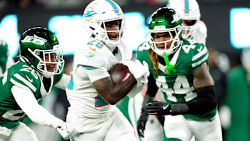 Miami Dolphins running back De'Von Achane (28) scores a touchdown after running past New York Jets cornerback Brandin Echols (26) and New York Jets linebacker Jamien Sherwood.