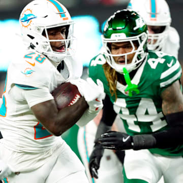 Miami Dolphins running back De'Von Achane (28) scores a touchdown after running past New York Jets cornerback Brandin Echols (26) and New York Jets linebacker Jamien Sherwood.