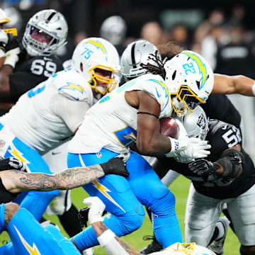 Sep 15, 2025; Paradise, Nevada, USA; Los Angeles Chargers running back Najee Harris (22) rushes the ball and is tackled by Las Vegas Raiders linebacker Elandon Roberts (52) during the second quarter at Allegiant Stadium. Mandatory Credit: Stephen R. Sylvanie-Imagn Images