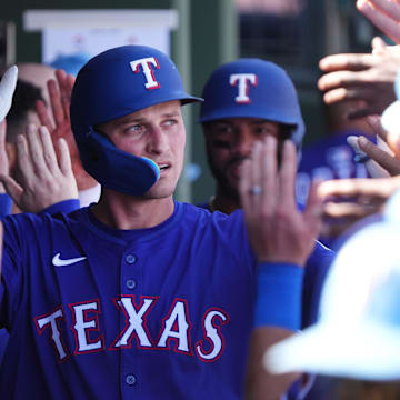 Texas Rangers inflieder Corey Seager (5) high-fives teammates after his 2-run home run against the Arizona Diamondbacks at Surprise Stadium on Sunday, March 2, 2025.
