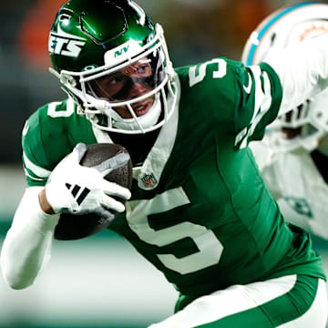 New York Jets wide receiver Garrett Wilson (5) runs with the ball past Miami Dolphins cornerback Jalen Ramsey (5), Sunday January 5, 2025, in East Rutherford.