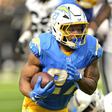 Sep 8, 2024; Inglewood, California, USA; Los Angeles Chargers running back J.K. Dobbins (27) breaks away from Las Vegas Raiders linebacker Divine Deablo (5) and runs for a touchdown in the second half at SoFi Stadium. Mandatory Credit: Jayne Kamin-Oncea-Imagn Images