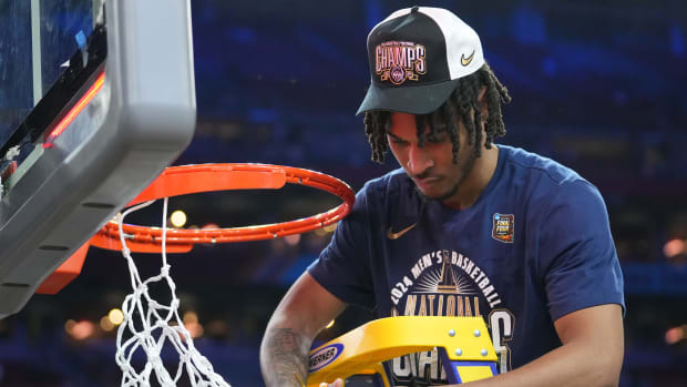 Connecticut Huskies guard Stephon Castle (5) cuts the basketball net after winning the Men's NCAA national championship game against the Purdue Boilermakers at State Farm Stadium in Glendale on April 8, 2024.