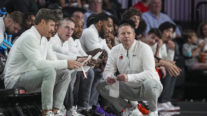 Nov 9, 2025; Athens, Georgia, USA; Georgia Bulldogs head coach Mike White (kneeling) watches the game action against the Morehead State Eagles at Stegeman Coliseum. Mandatory Credit: Dale Zanine-Imagn Images