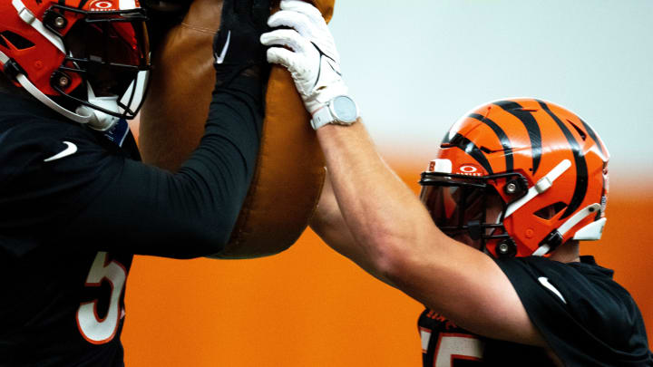 Cincinnati Bengals linebacker Logan Wilson (55) hits a pad held by Cincinnati Bengals linebacker Germaine Pratt (57) at Bengals spring practice at the IEL Indoor Facility in Cincinnati on Tuesday, June 11, 2024.