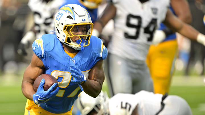 Sep 8, 2024; Inglewood, California, USA; Los Angeles Chargers running back J.K. Dobbins (27) breaks away from Las Vegas Raiders linebacker Divine Deablo (5) and runs for a touchdown in the second half at SoFi Stadium. Mandatory Credit: Jayne Kamin-Oncea-Imagn Images