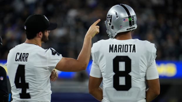 Las Vegas Raiders quarterbacks Derek Carr (4) and Marcus Mariota (8) watch the action from the sideline.